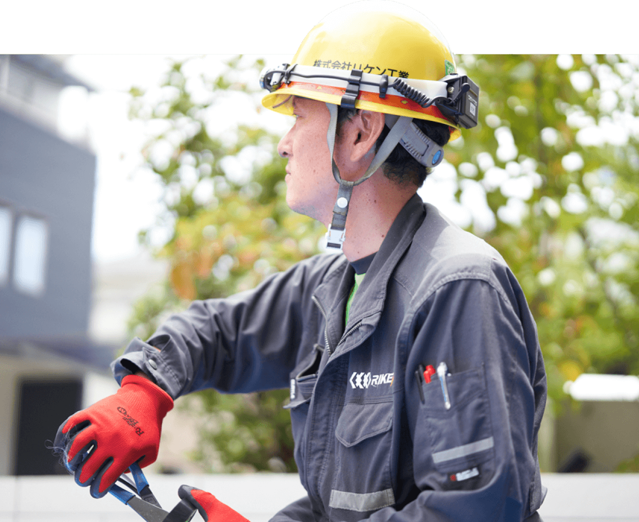 スタッフが作業服を着てヘルメットを被り、工具を持って作業をしている写真